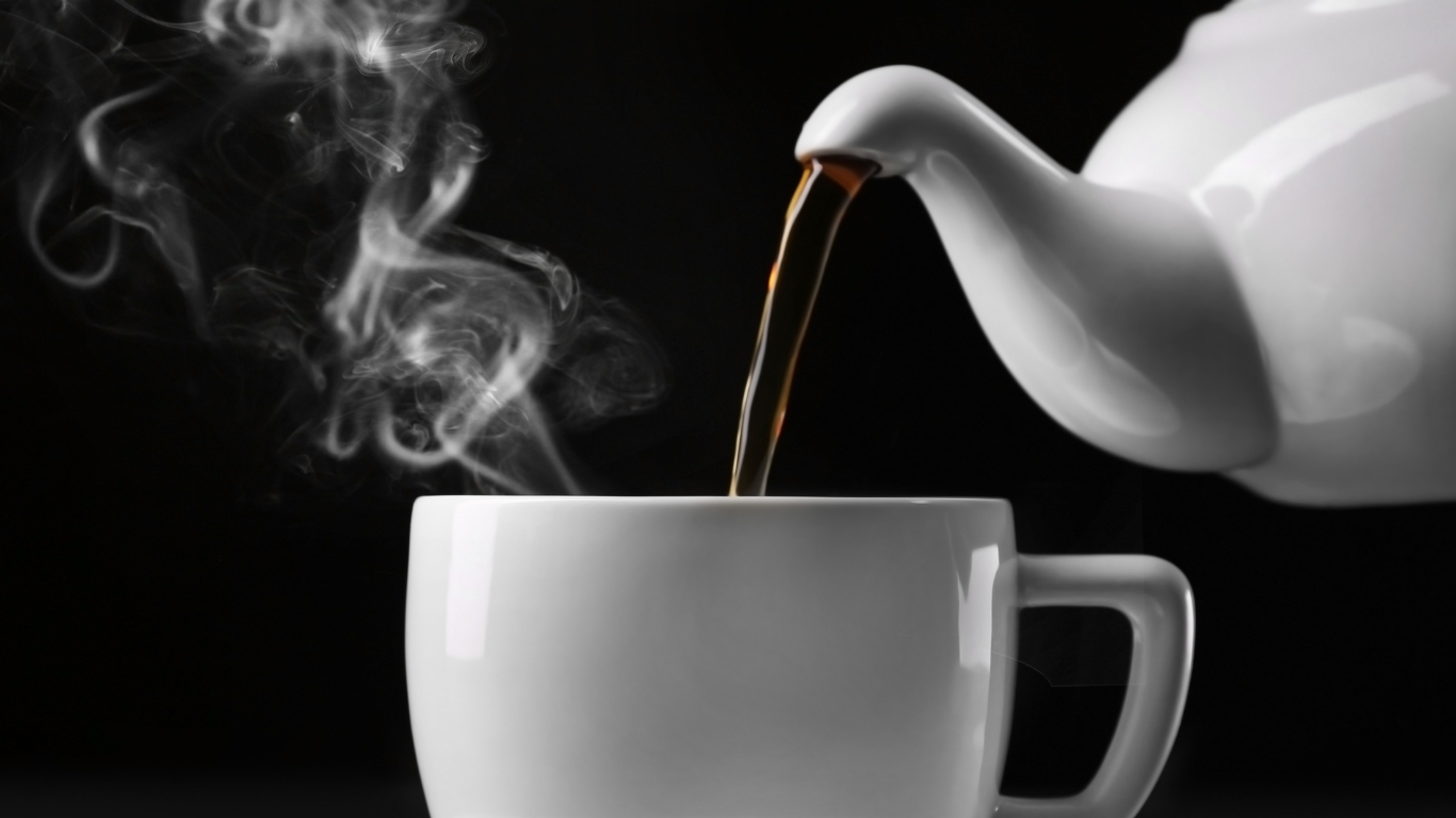 Someone pouring black tea from white tea pot in a white tea cup symbolizing the authentic high quality taste and aroma of sri lanka tea